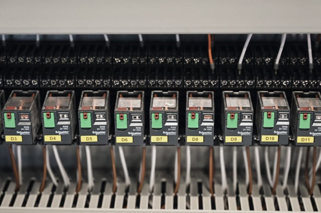 Relays and DIN-rail control modules inside a control panel